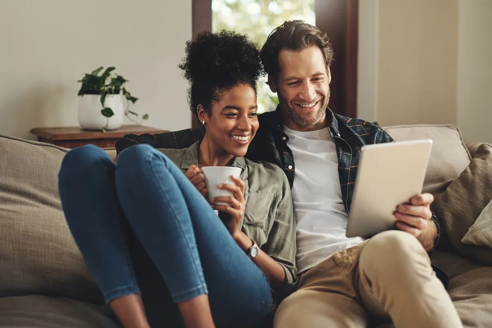 Couple relaxing at home with a free government phone and a tablet